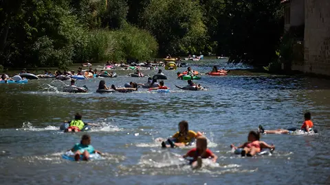 Chapuzón en el rio Ega tras el Chupinazo que da comienzo a las fiestas de Estella. MIGUEL OSÉS