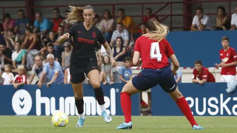 Una jugadora del Atlético de Madrida intenta regatear a una jugadora de Osasuna ATM