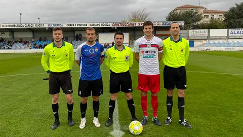 El trio arbitral y capitanes del Peña Sport - Beti Kozkor en Tafalla. @PenaSportFC.