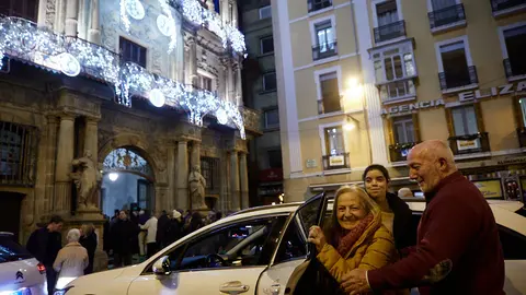 El alcalde, Enrique Maya, recibe a personas de residencias de la tercera edad que recorren en taxi la ciudad para ver las luces y el ambiente navideño de Pamplona. IÑIGO ALZUGARAY