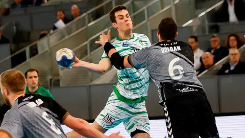 El jugador de Helvetia Anaitasuna, Ander Izquierdo (c), se dispone a lanzar ante la defensa del Liberbank Cuenca, Doldan, durante el encuentro de cuartos de final de la Copa del Rey de Balonmano que se disputa en la caja Mágica de Madrid. EFE/David Fernández.