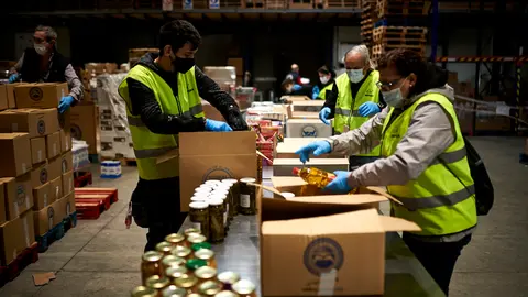 Voluntarios de Banco de Alimentos de Navarra y de ASVONA empaquetan comida en cajas para llevarlas a las casas de personas con necesidad durante la crisis del coronavirus. PABLO LASAOSA