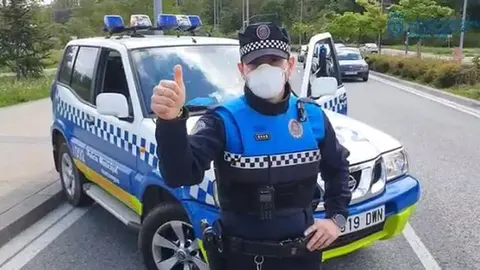 Un agente de la Policía Municipal de Pamplona junto a su vehículo.