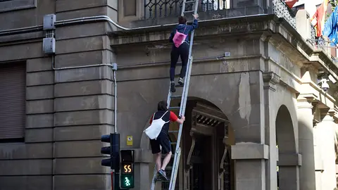 Tres personas asaltan Delegación de Gobierno y se encadenan en las banderas del balcón. MIGUEL OSÉS