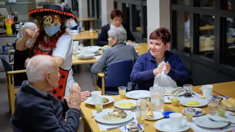 El personal sociosanitario, disfrazado para la ocasión, entretiene durante la cena a los residentes de Amavir Oblatas. MIGUEL OSÉS