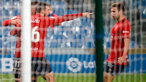 El delantero argentino del Osasuna, Jonathan Calleri (i), celebra con sus compañeros su gol ante la Real Sociedad , durante el partido de LaLiga Santander que han disputado este domingo en el estadio Reale Arena de San Sebastián. EFE/Javier Etxezarreta