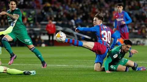 El centrocampista del FC Barcelona, Gavi (2d), intenta rematar antes el defensa de Osasuna, Nacho Vidal, en la jugada que ha significado el penalti a favor del equipo blaugrana, durante el encuentro correspondiente a la jornada 28 de primera división que disputan hoy Domingo en el estadio Camp Nou de Barcelona. EFE / Toni Albir.