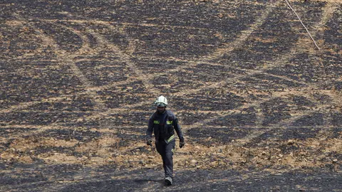 Un retén de bomberos trabajan en la extinción y control del incendio de la sierra del Perdón. IÑIGO ALZUGARAY