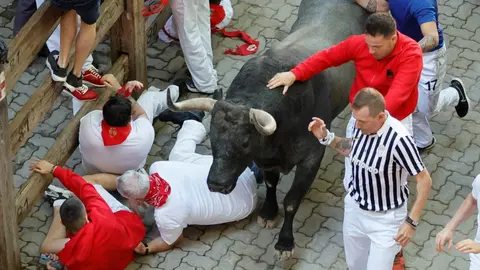 Los mozos corren ante los toros de la ganadería de José Escolar durante el tercer del encierro de San Fermín, este sábado. EFE. Villar Lopez
