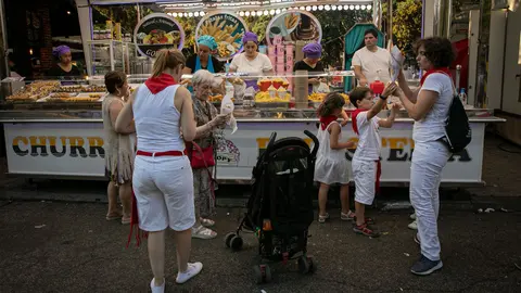 Cientos de personas disfrutan de los tradicionales puestos de vino añejo, churros, pollos asados, o puestos ambulantes del parque Antoniutti y Taconera. MAITE H. MATEO