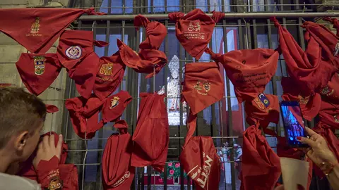 Pamploneses y visitantes dejan velas y pañuelos a las puertas de la iglesia de San Lorenzo, en cuyo interior se encuentra la capilla de San Fermín, tras el "Pobre de mí" de los Sanfermines 2022. IÑIGO ALZUGARAY