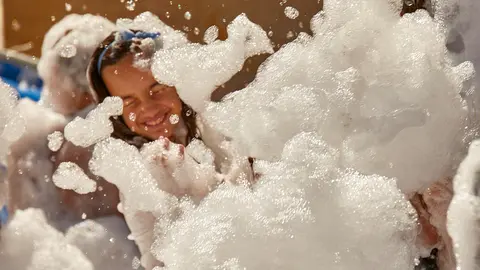 Niños y niñas disfrutan de la Fiesta de la Espuma en la Plaza de las Eras tras el lanzamiento del Chupinazo de inicio de las Fiestas de Burlada 2022. IÑIGO ALZUGARAY