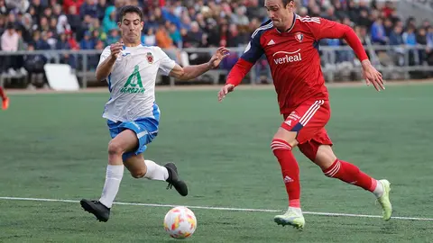 FUENTES DE EBRO (Zaragoza), 12/11/2022.- El lateral del Fuentes Javi Marcen (i) disputa el balón ante el delantero de Osasuna Kike durante la primera eliminaJAtoria de la Copa del Rey disputado hoy Sábado en el estadio San Miguel en la localidad aragonesa de Fuentes de Ebro.  EFE / Javier Cebollada.
