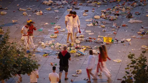 GRAFCAV635. PAMPLONA, 08/07/2023.- Los más trasnochadores deambulan por la Plaza del Castillo de Pamplona entre la basura acumulada tras la primera noche del fin de semana de los Sanfermines 2022 antes del encierro de este sábado. EFE/ Villar López
