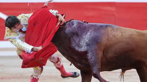 El diestro Adrián Torres sufre un percance al entrar a matar a su segundo toro en suerte esta tarde en la Plaza de Toros de Pamplona dentro de la Feria del Toro de los Sanfermines 2023, donde ha compartido cartel con Román Collado e Isaac Fonseca con toros de la ganadería gaditana de José Cebada Gago. EFE - Villar López