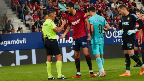 Miguel Angel Ortiz Arias (árbitro del partido), Alejandro Catena (24. CA Osasuna), Robert Lewandowski (9. FC Barcelona) y Aitor Fernández (13. CA Osasuna) durante el partido de La Liga EA Sports entre CA Osasuna y FC Barcelona disputado en el estadio de El Sadar en Pamplona. IÑIGO ALZUGARAY