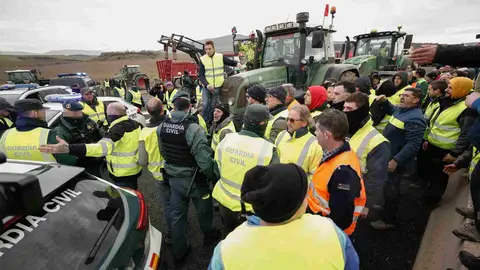 Agricultores en los accesos a Pamplona por el nudo de Cizur donde han apartado un coche patrulla de la Guardia Civil para poder pasar. EFE