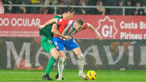 Jorge Herrando trata de sujetar a un rival en el partido de Osasuna contra el Girona en Montilivi. EFE