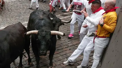 Mozos perseguidos por los toros de Victoriano del Río en el tercer encierro de los Sanfermines este martes, en Pamplona. EFE/Jesús Diges