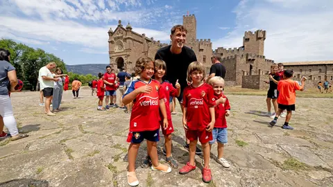 Jorge Herrando posa junto a unos aficionados rojillos en la tradicional ofrenda. OSASUNA