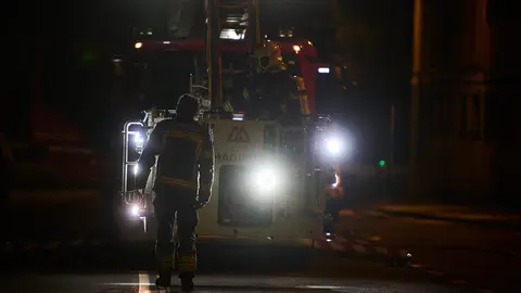 Los bomberos trabajan por la noche en la extinción de incendio originado en las dependencias de la Policía Municipal de Pamplona. PABLO LASAOSA