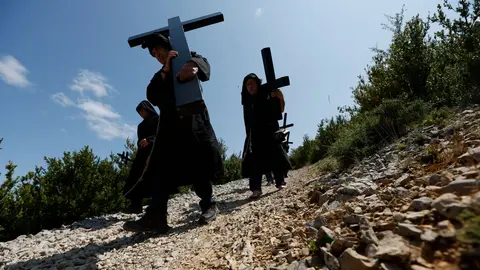 Penitentes de la hermandad de Los Cruceros vestidos con túnicas negras portan pesadas cruces de madera y caminan hasta la ermita de la Trinidad, a 740 metros de altitud. Esta romería penitencial se celebra desde el siglo XIX el dia de la Santísima Trinidad, el primer domingo después de Pentecostés. EFE / Jesús Diges