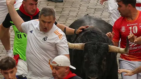 Juampe Lecuona. Mozos son perseguidos por uno de los toros de la ganader&iacute;a gaditana de Fuente Ymbro en el tramo final que desemboca en el callej&oacute;n de la Plaza de Toros, durante el primer encierro de los Sanfermines 2025, este lunes en Pamplona. EFE/ J.P. Urdiroz