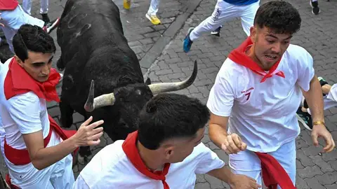 Varios  mozos perseguidos por uno de los toros de la ganader&iacute;a gaditana de Fuente Ymbro, durante el primer encierro de los Sanferimes 2026, este martes en Pamplona. EFE/Daniel Fern&aacute;ndez P&eacute;rez