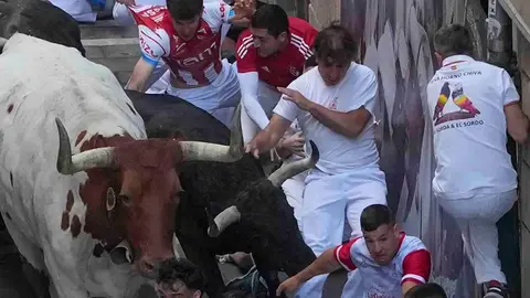 Varios  mozos perseguidos por un cabestro y uno de los toros de la ganader&iacute;a gaditana de Fuente Ymbro en el tramo de la Estafeta, durante el primer encierro de los Sanferimes 2026, este martes en Pamplona. EFE/Ainhoa Tejerina