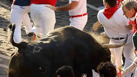 Un toro de la ganader&iacute;a extreme&ntilde;a de Jandilla embiste a varios mozos al principio de la calle Mercaderes, durante el &uacute;ltimo encierro de los Sanfermines 2026, este martes en Pamplona. EFE/Villar L&oacute;pez