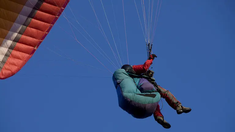 Un hombre realiza un paseo en parapente.