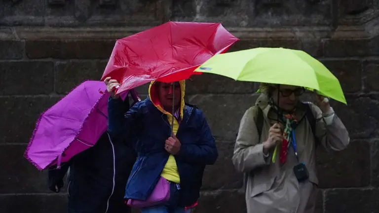 Varias personas se resguardan bajo un paraguas de la lluvia, el viento y el mal tiempo. &Aacute;LVARO BALLESTEROS / EUROPA PRESS
