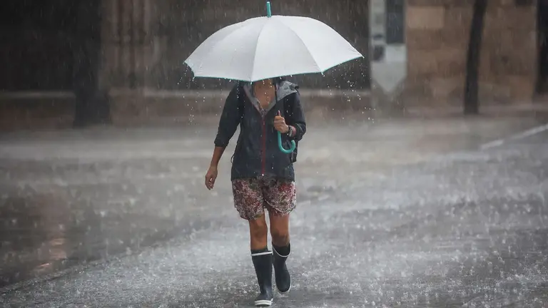Varias personas se resguardan bajo un paraguas de la lluvia, el viento y el mal tiempo. ROBER SOLSONA / EUROPA PRESS