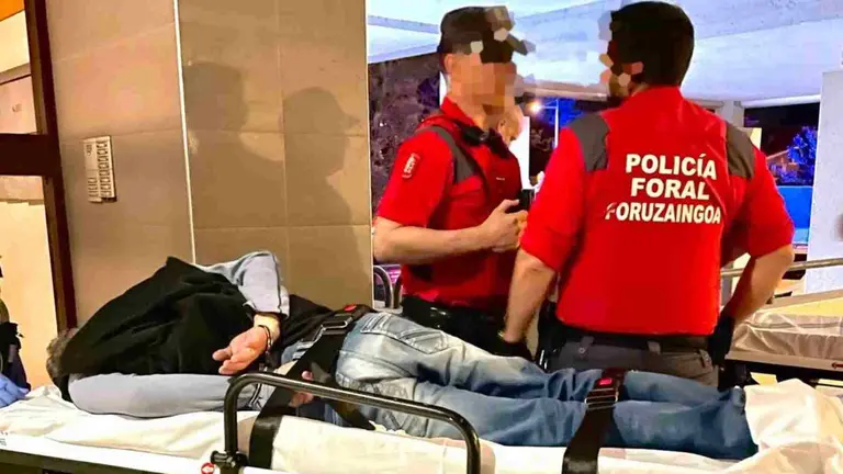 Dos agentes de la polic&iacute;a Foral custodian al presunto autor material de los disparos tras su detenci&oacute;n en Zizur Mayor. POLIC&Iacute;A FORAL