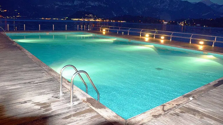 Una piscina iluminada por la noche. PIXABAI