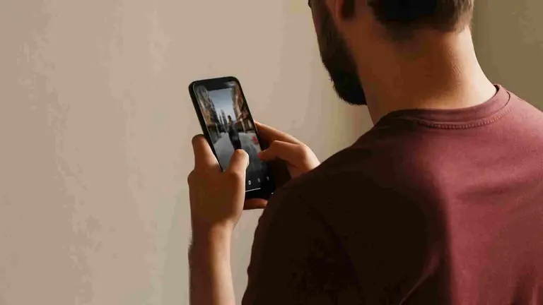Imagen generada por IA de un hombre utilizando un tel&eacute;fono m&oacute;vil.