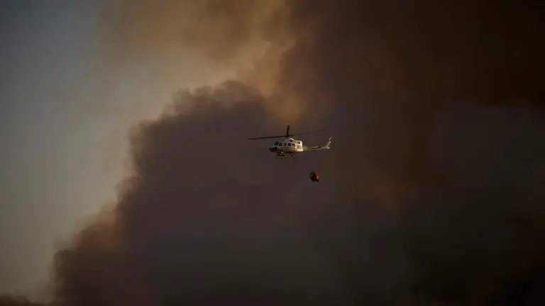 Efectivos de Bomberos, Polic&iacute;a Foral, Guardia Civil, aviones y helic&oacute;pteros trabajan para sofocar el incendio forestal declarado en Carcastillo. PABLO LASAOSA