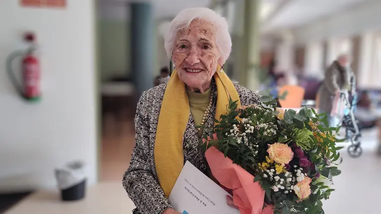 Paca Cruz sostiene el ramo de flores por su 102 cumplea&ntilde;os en Tudela. Residencia Real Casa de Misericordia.
