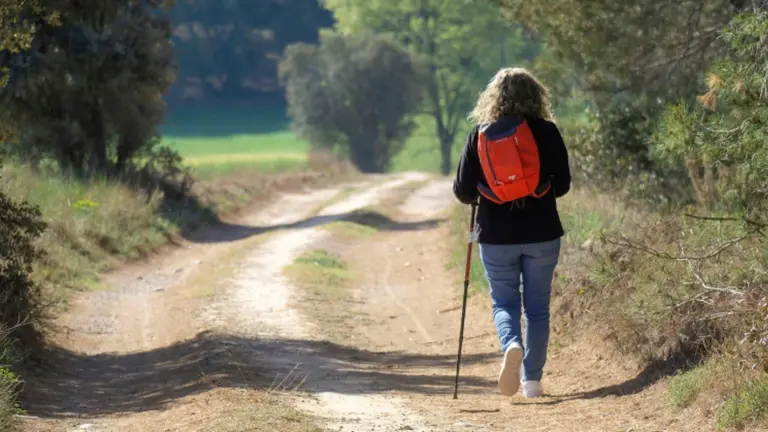 Una mujer camina por un camino. ARCHIVO