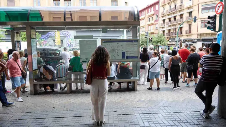 Varias personas aguardan en una parada de villavesa de Pamplona. I&Ntilde;IGO ALZUGARAY