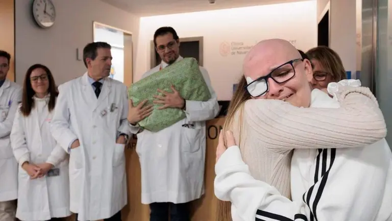 Enric abraza a su hermana tras el final del tratamiento. Al fondo, los m&eacute;dicos que lo han cuidado se despiden con un regalo y los mejores deseos.  FOTOGRAF&Iacute;A: Jos&eacute; Juan Rico