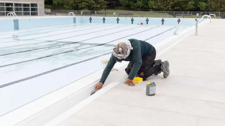 Un operario trabajando en la puesta a punto de las piscinas de Aranzadi para el verano. AYUNTAMIENTO DE PAMPLONA