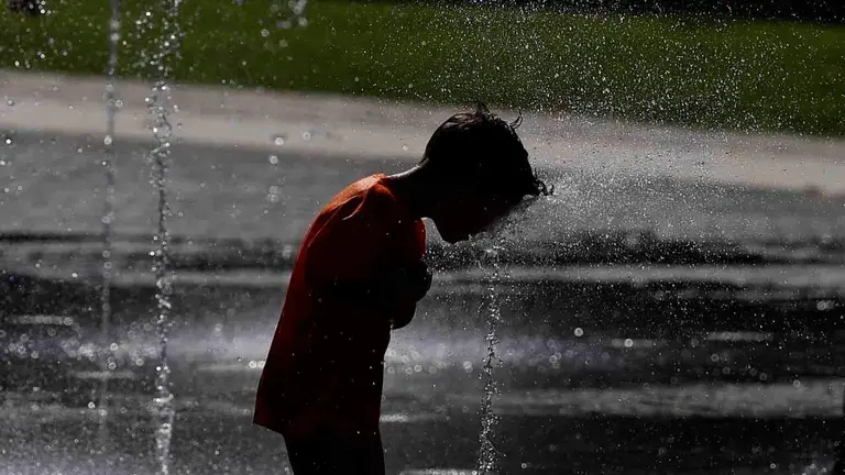 Un ni&ntilde;o se refresca en unos chorros de agua. EFE/ Rodrigo Jim&eacute;nez