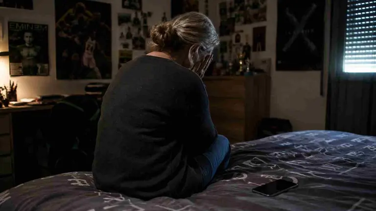 Una mujer llora sobre una cama. Recreaci&oacute;n del suceso por inteligencia artificial.