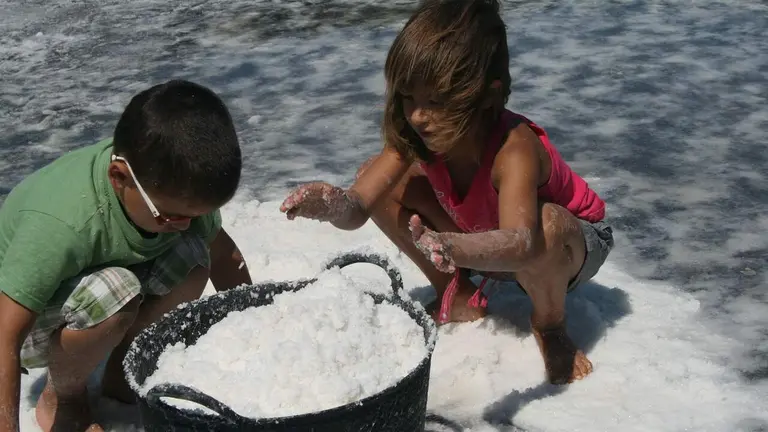 Unos ni&ntilde;os juegan con la sal en Salinas de Oro. TIERRAS DE IRANZU
