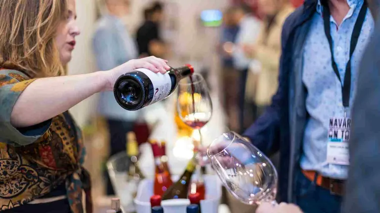 Una somelier sirve vino de la D.O Navarra en una feria. D O. NAVARRA.