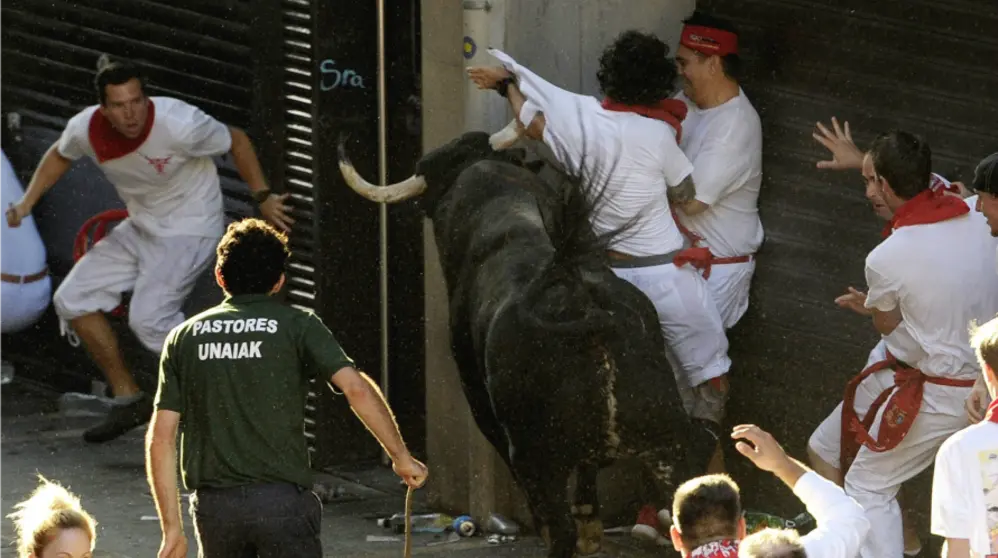 Un toro de la ganadería gaditana de Cebada Gago cren una situación de peligro ante un grupos de mozos a la entrada de la calle Mercaderes de Pamplona . EFEVillar López