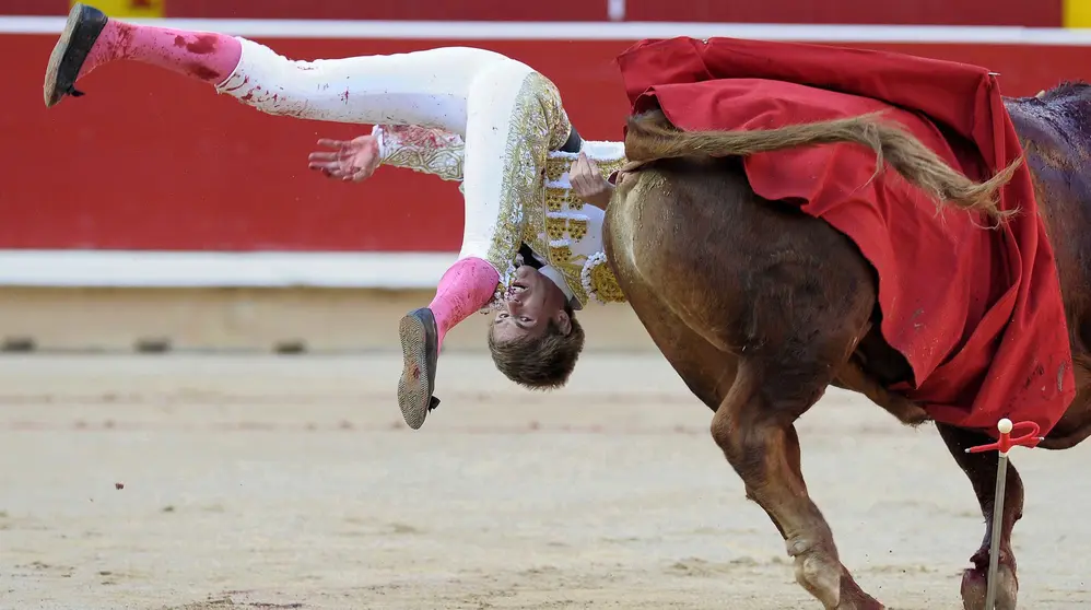 GRA416. PAMPLONA, 08/07/2016.- El torero sevillano Javier Jiménez es volteado durante la lidia a su primer toro de la tarde, en la cuarta de abono de la Feria del Toro de San Fermín hoy en la Plaza de Toros de Pamplona, en la que ha compartido cartel con Pepe Moral y Eugenio de Mora. EFE/Villar López