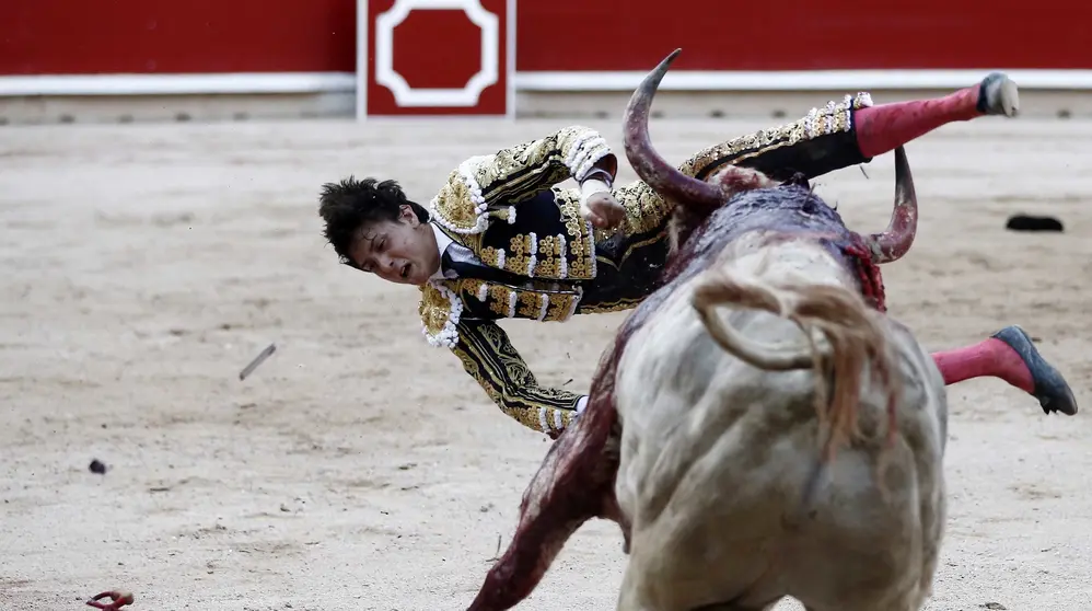 GRA428. PAMPLONA, 11/07/2017.- El diestro peruano Andr&eacute;s Roca Rey volteado al entrar a matar al segundo de su lote, durante el s&eacute;ptimo festejo de los Sanfermines, en el que comparte cartel con los matadores, Cayetano Rivera y Miguel &Aacute;ngel Perera, lidiando toros de Jandilla. EFE/Jes&uacute;s Diges