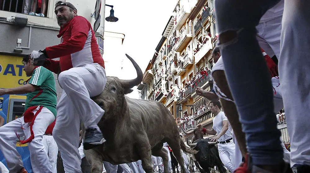 GRAF7831. PAMPLONA, 11/07/2018.- Los toros de la ganadería gaditana de Núñez del Cuvillo enfilan junto a mansos y corredores la curva de Mercaderes con la calle Estafeta durante el quinto encierro de los Sanfermines 2018 que ha resultado emocionante y vistoso con huecos entre los animales que han realizado el recorrido estirados, sin que al parecer ningún corredor haya resultado corneado. EFE/Jesús Diges